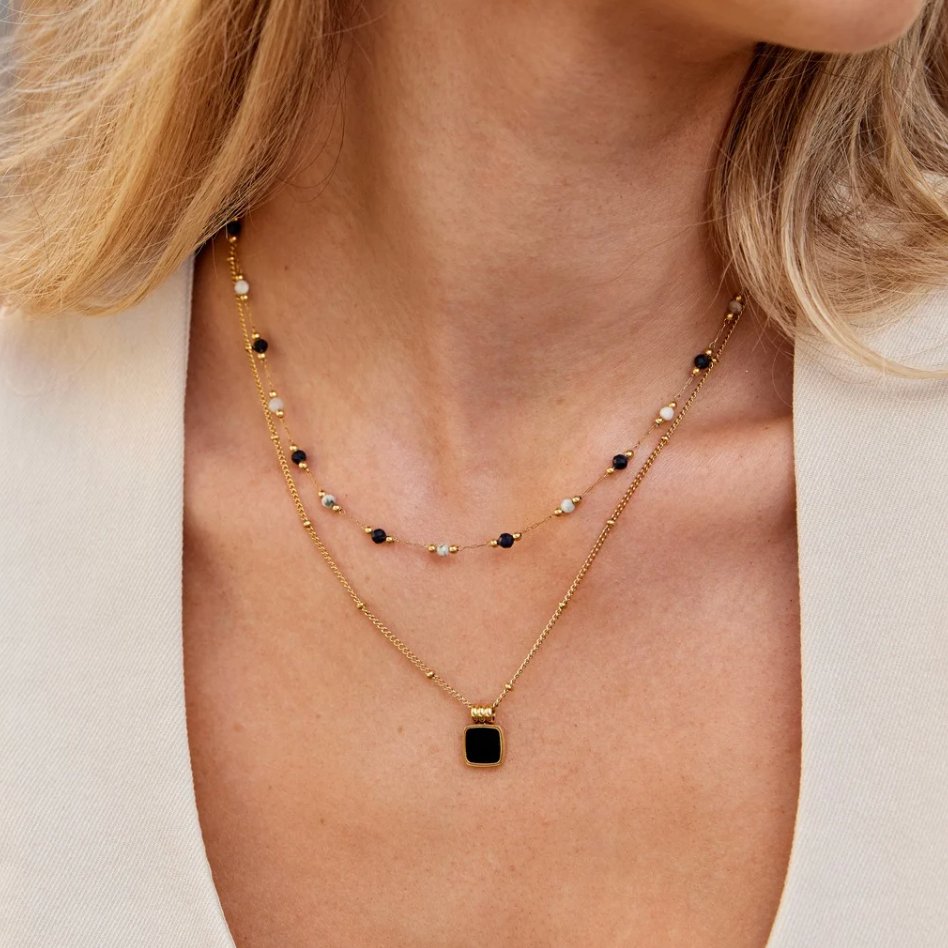 Selina – Collar dorado con piedra oscura.