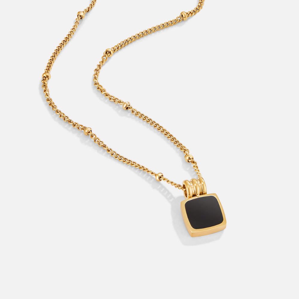 Selina – Collar dorado con piedra oscura.